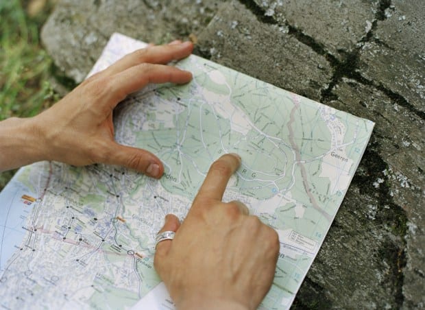 Man’s hand pointing on street map